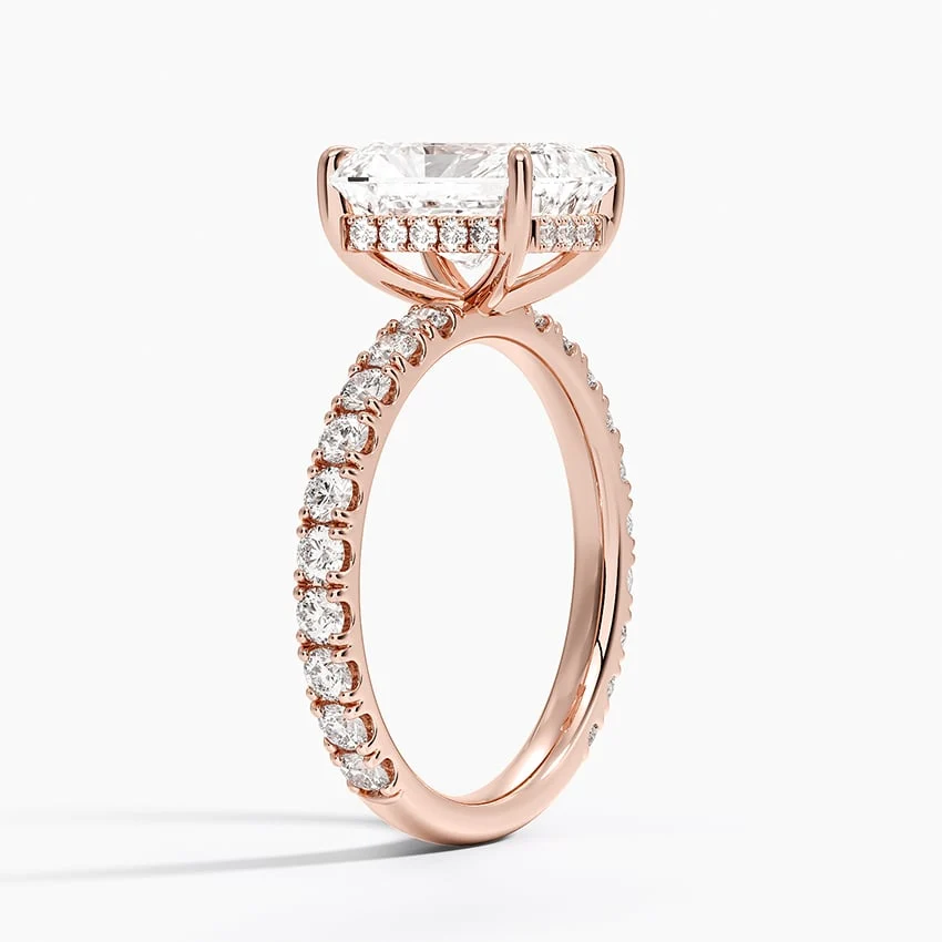 Rose gold radiant cut moissanite engagement ring 3/4 side perspective view showing claw prongs and scalloped shank