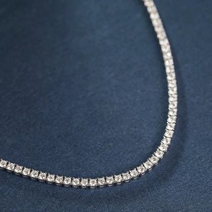 Close up detail of 3mm round brilliant moissanite stones in 4-prong setting on silver tennis chain