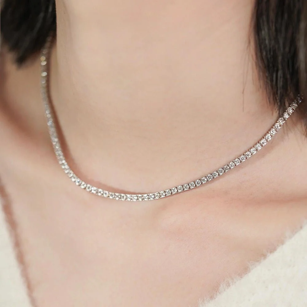 3mm round moissanite iced tennis chain necklace in white gold plated sterling silver worn on model collarbone