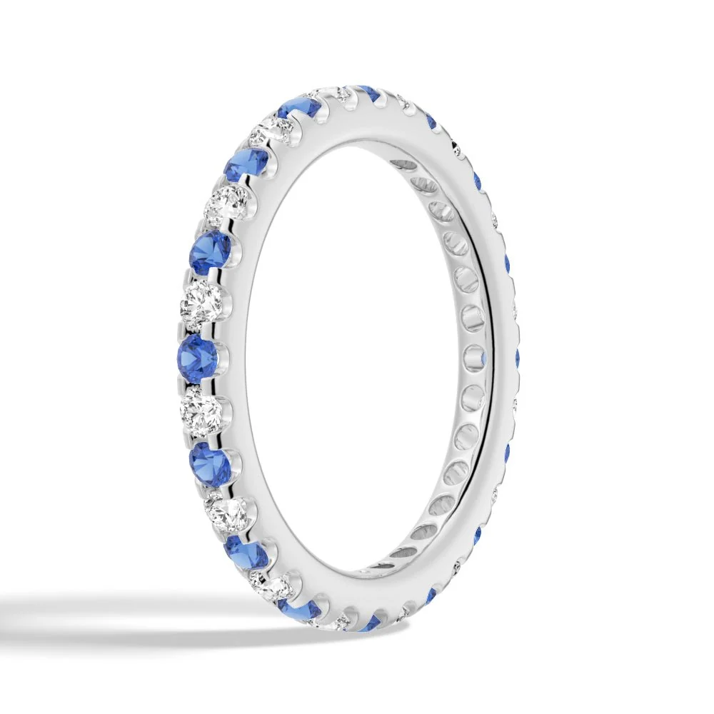 Perspective side angle view of alternating blue and white sapphire eternity band in white gold