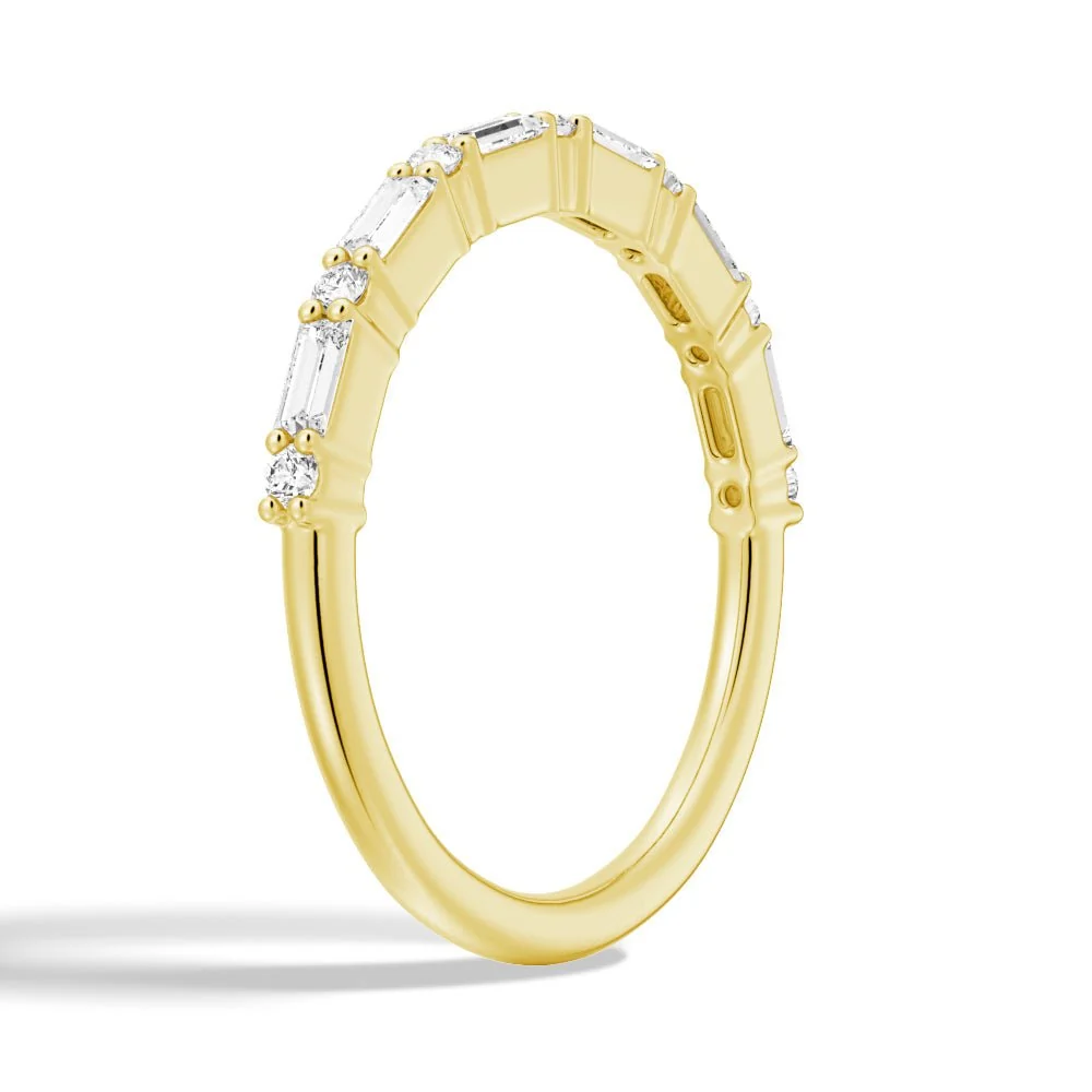 Three-quarter perspective view of baguette and round moissanite wedding band in yellow gold