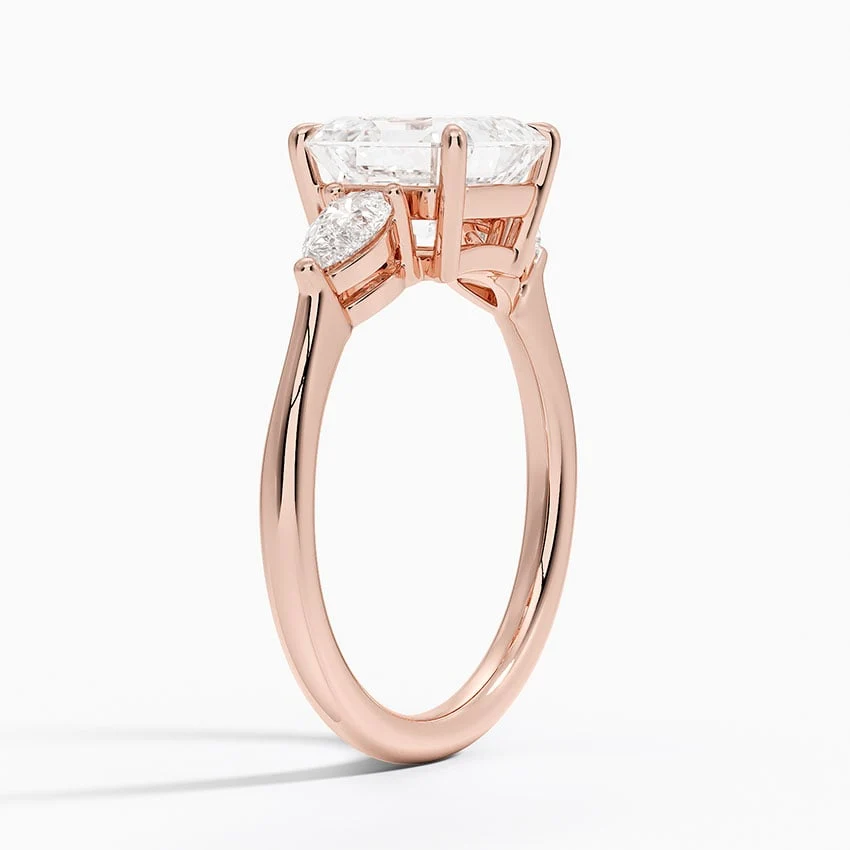 Rose gold classic three-stone asscher cut moissanite engagement ring 3/4 side view showing claw prong basket