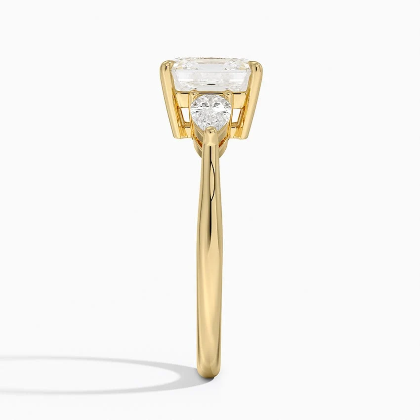 Yellow gold classic three-stone asscher cut moissanite engagement ring direct side profile view showing prong set pear accents