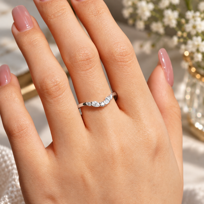 White gold curved multi-shape moissanite wedding band worn on female hand