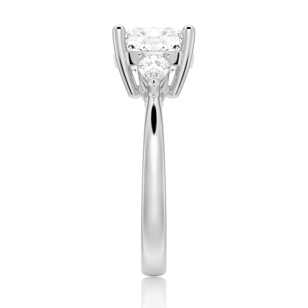 White gold cushion cut moissanite three stone engagement ring direct side view showing pear side stones