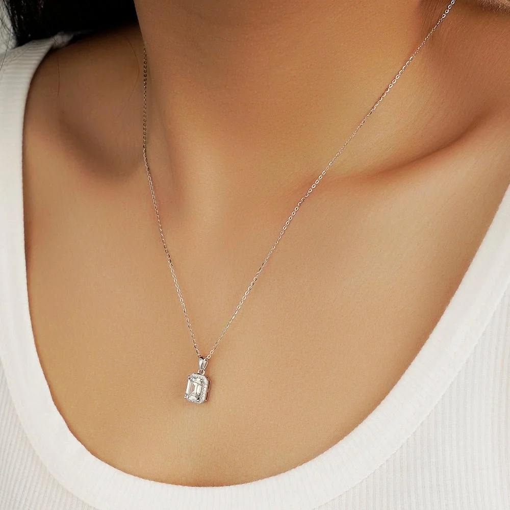 Emerald cut moissanite halo pendant necklace side perspective view on model