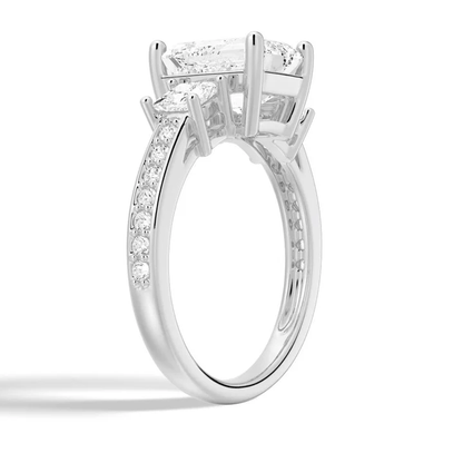 Angled profile view of Emerald Cut Three Stone Moissanite Engagement Ring with Pave Band in White Gold