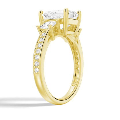 Angled profile view of Emerald Cut Three Stone Moissanite Engagement Ring with Pave Band in Yellow Gold