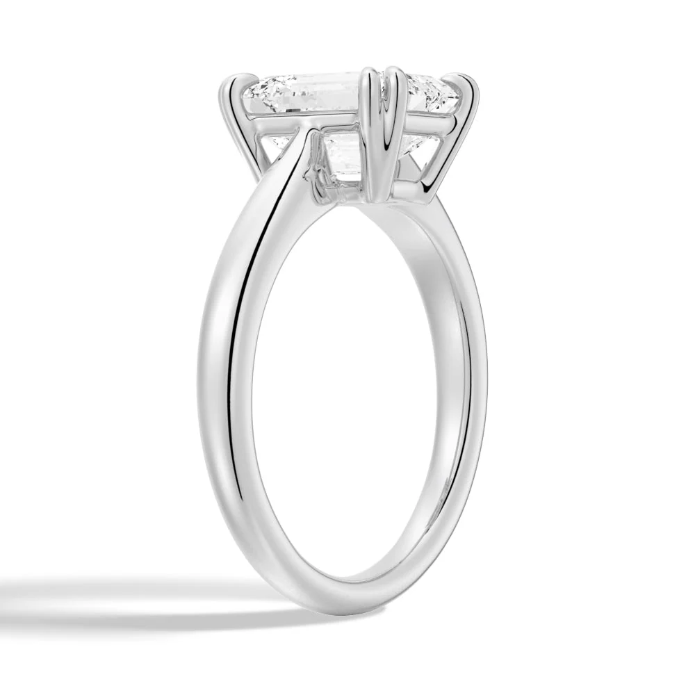 White gold emerald cut moissanite engagement ring 3/4 side low angle perspective view showing plain band