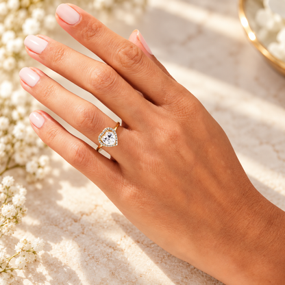 Yellow gold heart shaped moissanite halo engagement rings shown on hand in multiple carat sizes