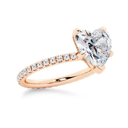 Rose gold heart shaped moissanite engagement ring side profile perspective view showing three prong basket