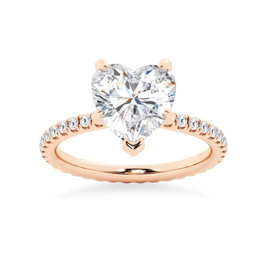 Rose gold heart shaped moissanite engagement ring side profile perspective view showing three prong basket