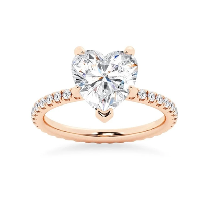 Rose gold heart shaped moissanite engagement ring side profile perspective view showing three prong basket