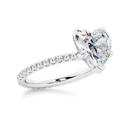 White gold heart shaped moissanite engagement ring tilted perspective view with pave diamond band