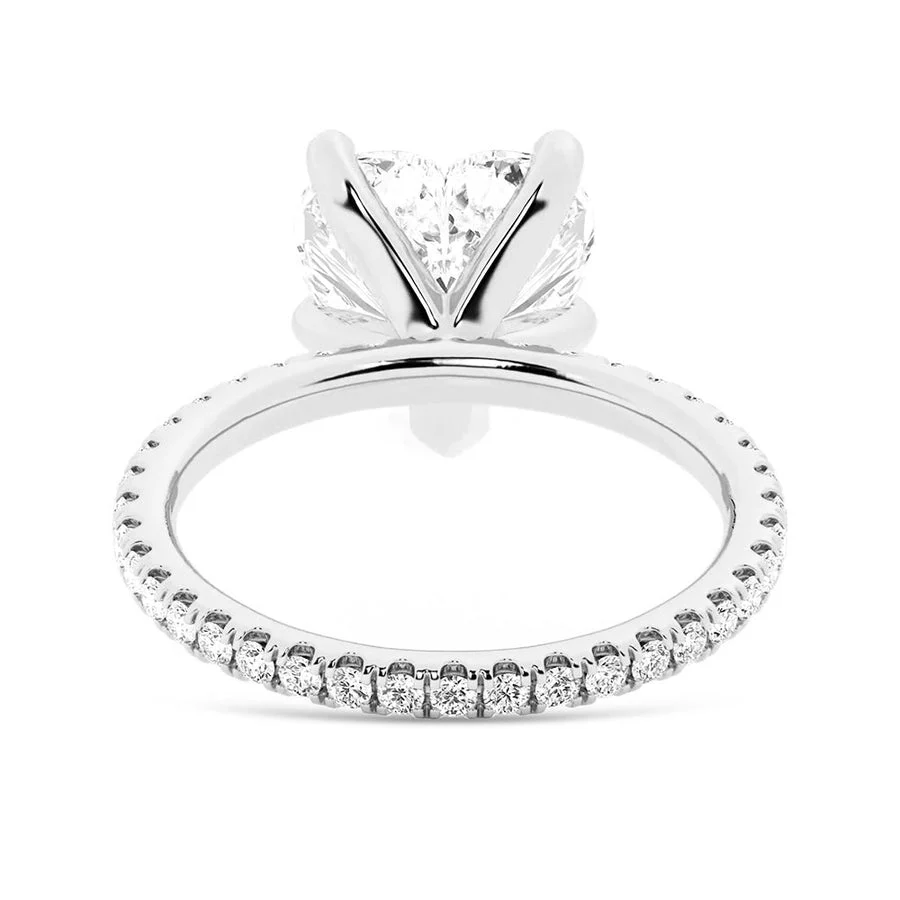 White gold heart shaped moissanite engagement ring side profile perspective view showing three prong basket