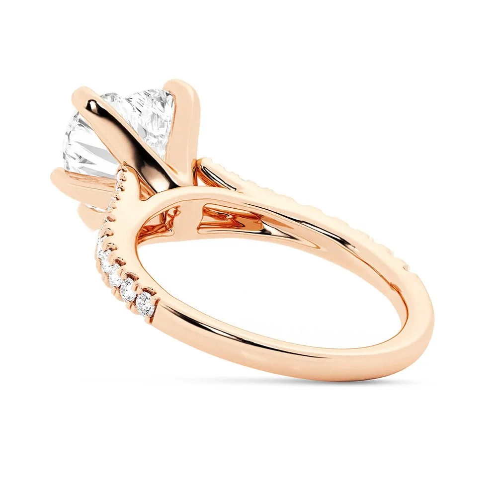 Rose gold heart shaped moissanite engagement ring tilted side view showing three prong setting