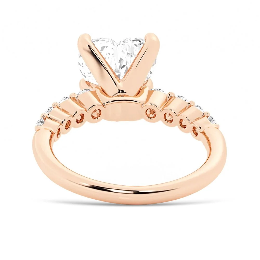 Rose gold heart shaped moissanite engagement ring side profile view showing shared prong basket and open gallery