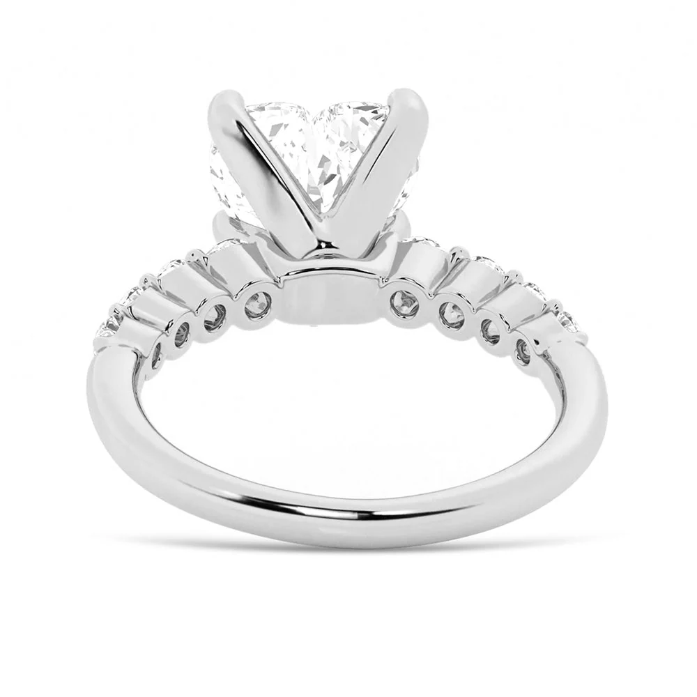 White gold heart shaped moissanite engagement ring side profile view showing shared prong basket and open gallery