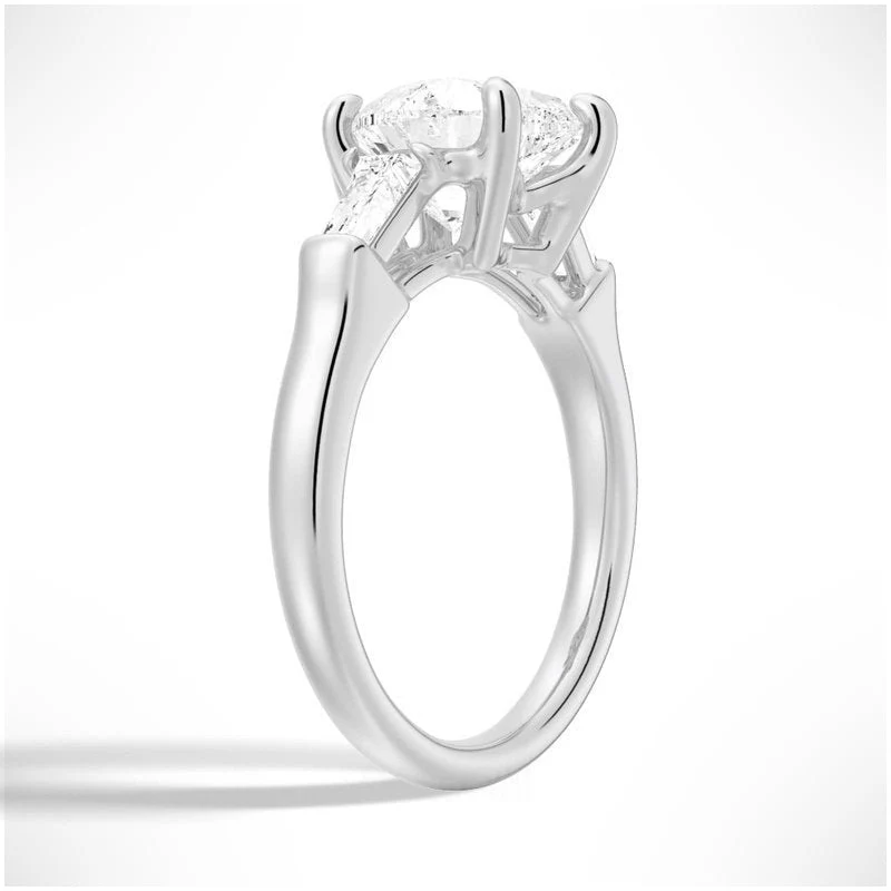 White gold heart shaped moissanite engagement ring 3/4 side low angle perspective view showing tapered baguette side stones