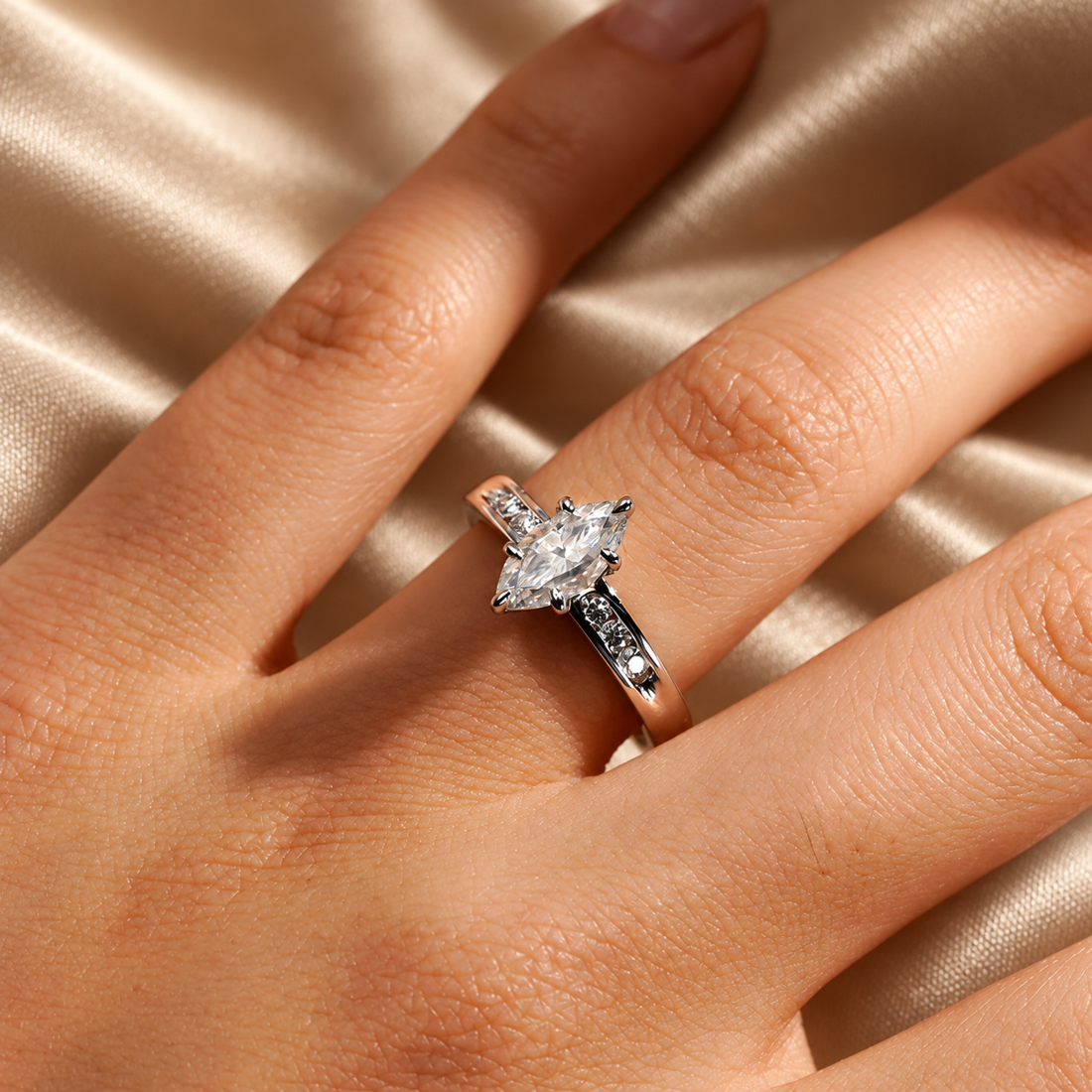 White gold marquise cut moissanite engagement ring close up on model hand in natural lighting