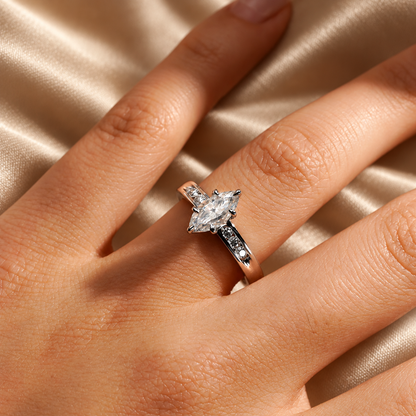 White gold marquise cut moissanite engagement ring close up on model hand in natural lighting