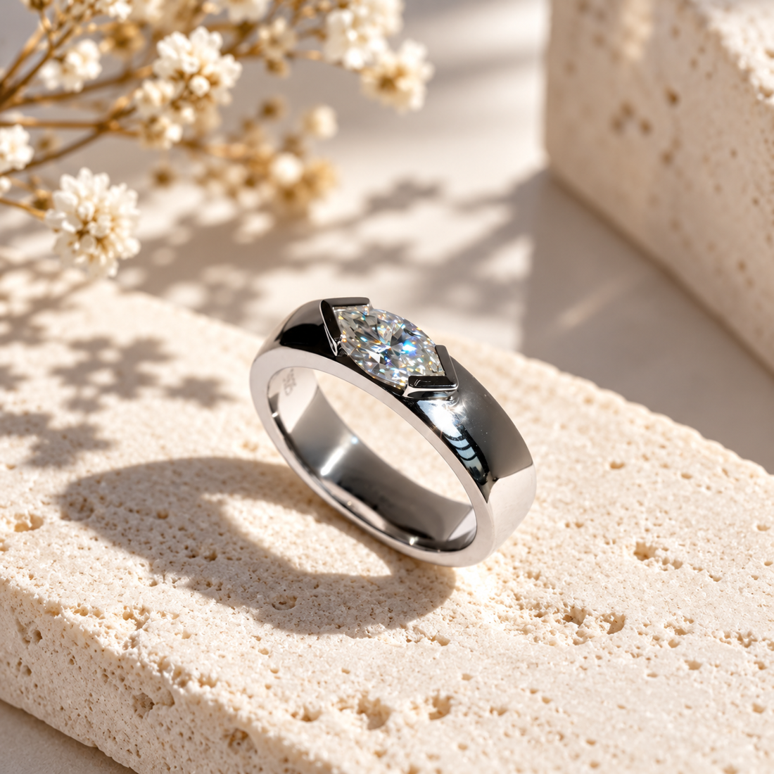 White gold marquise cut moissanite east-west half bezel solitaire ring close up view on stone surface