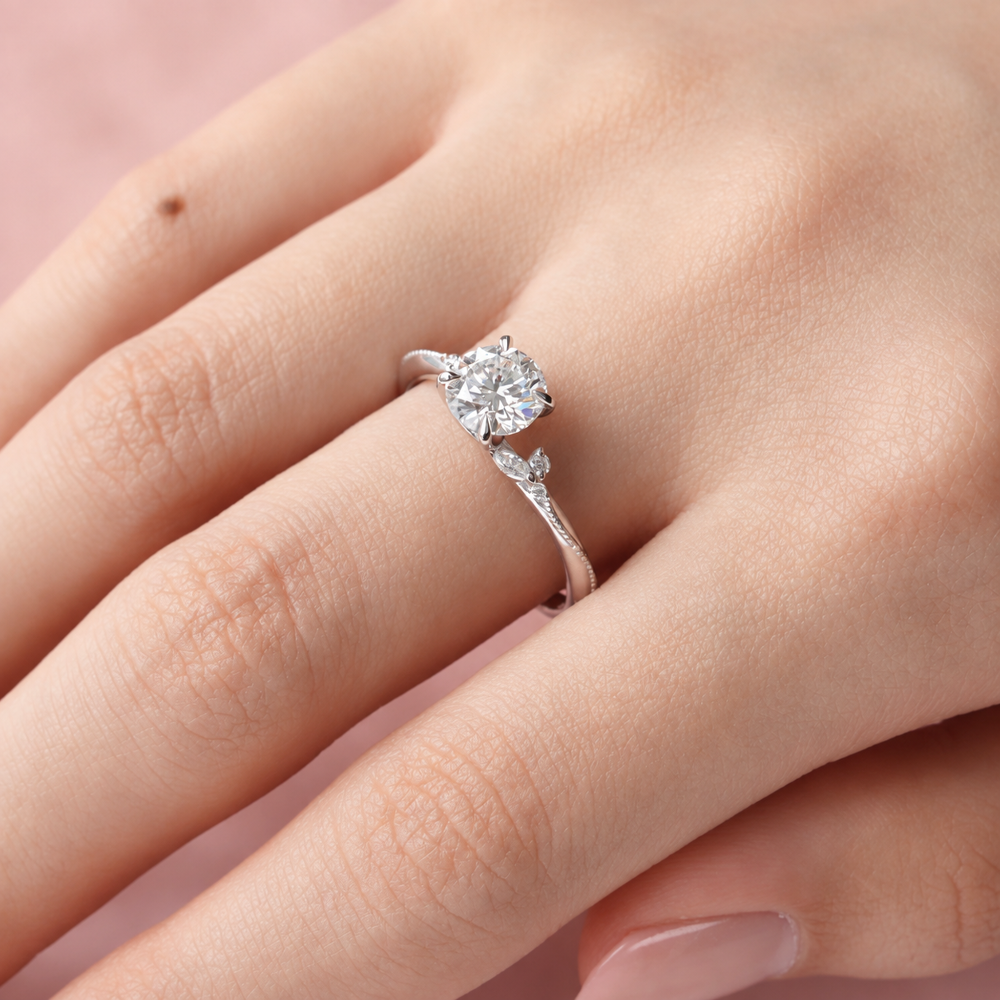 On-hand view of round moissanite solitaire engagement ring with marquise leaf accents in white gold