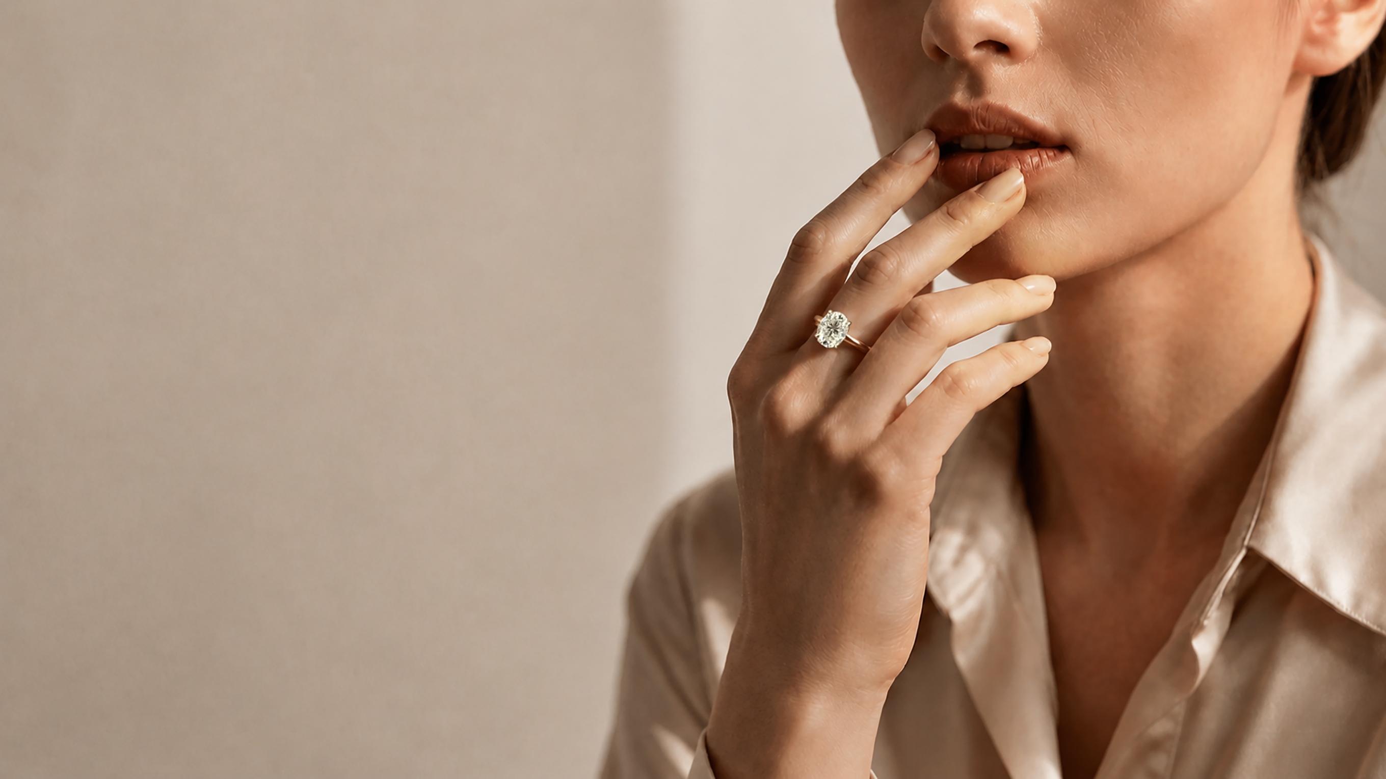 Woman wearing an oval moissanite engagement ring in gold setting