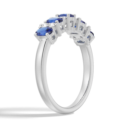 Three-quarter perspective view of oval blue sapphire and round white sapphire alternating ring