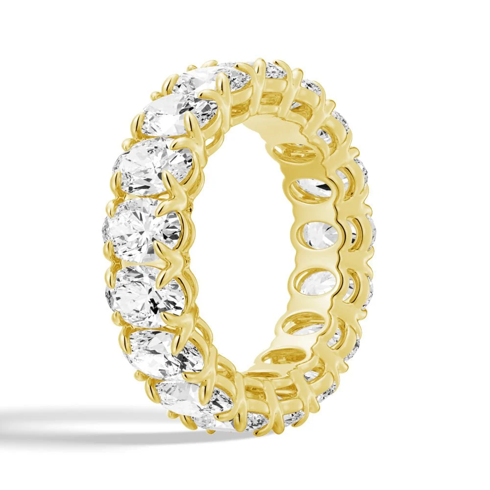 Vertical top view of yellow gold oval moissanite eternity band