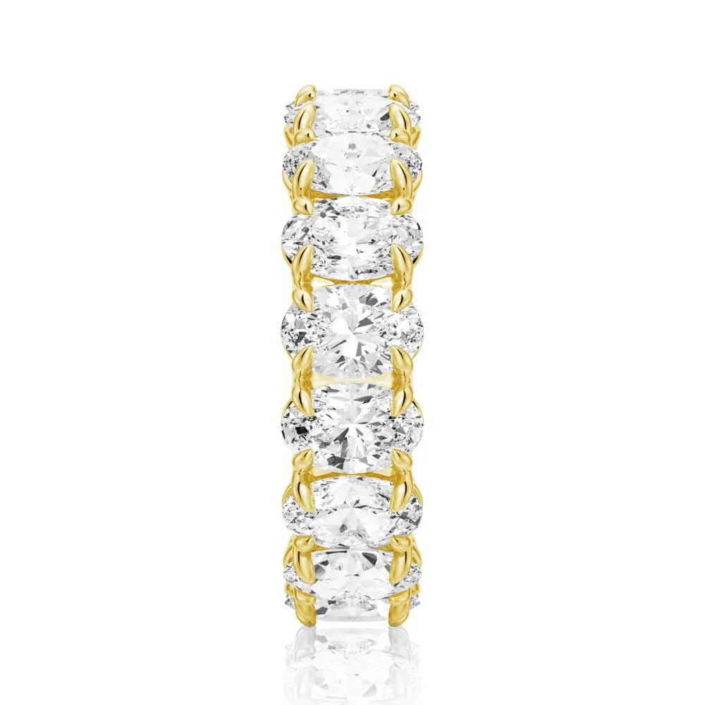 Vertical top view of yellow gold oval moissanite eternity band