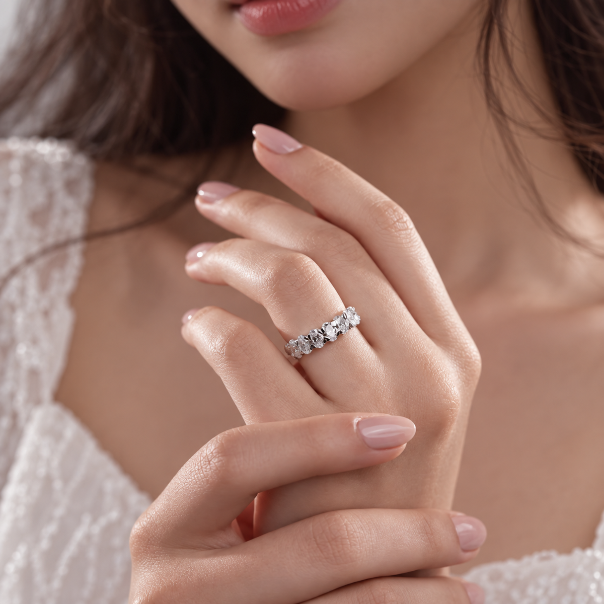 Model wearing white gold oval cut moissanite seven stone wedding band on hand