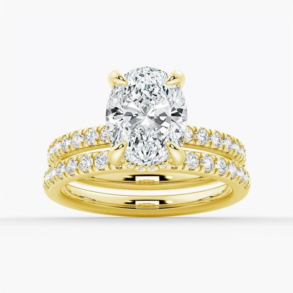 Yellow gold oval moissanite bridal set with pave engagement ring and matching wedding band