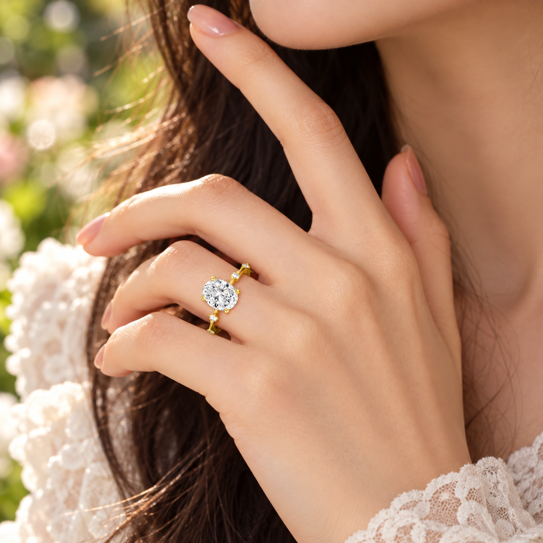 Model wearing an oval moissanite engagement ring with hidden halo and spaced accents in yellow gold.
