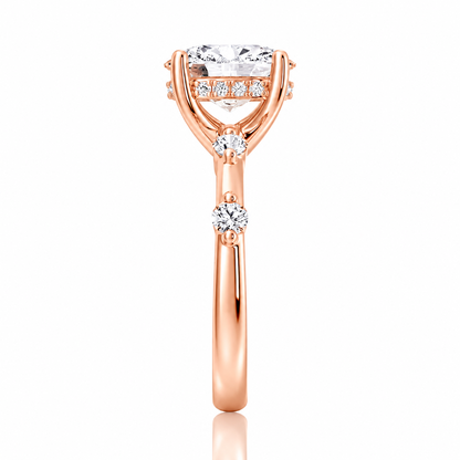 Rose gold oval moissanite ring side view displaying spaced accent stones along the bandRose gold oval moissanite ring side view displaying spaced accent stones along the band