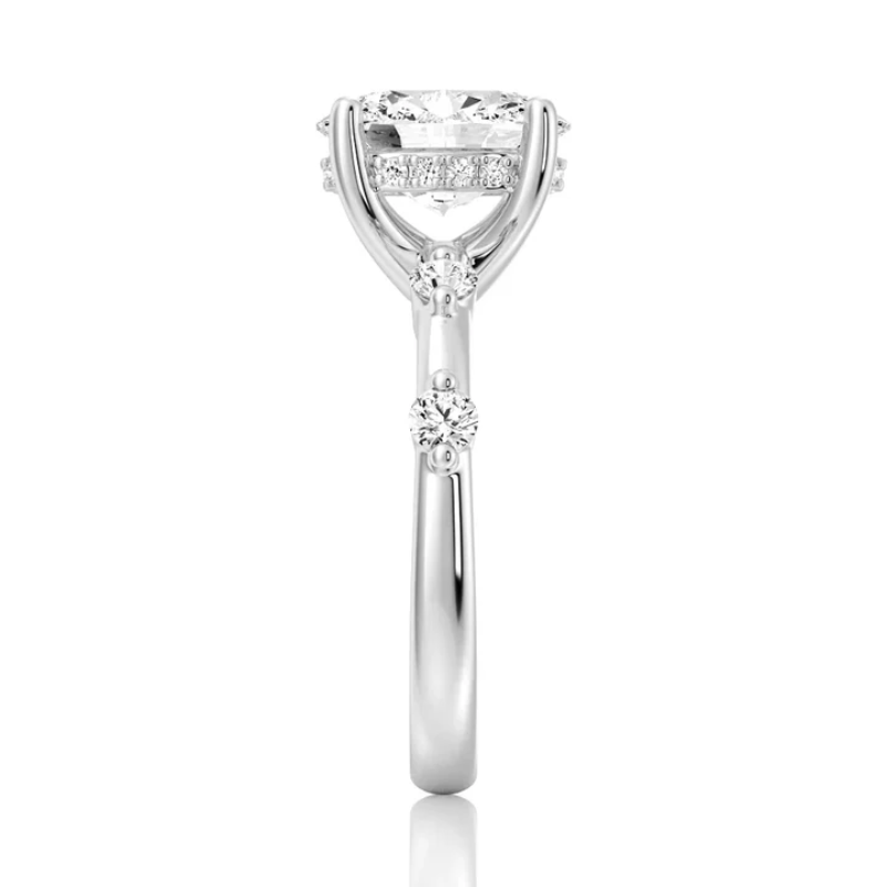 White gold oval moissanite ring side view displaying bezel spaced stones along the band