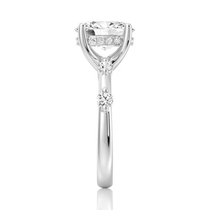 White gold oval moissanite ring side view displaying bezel spaced stones along the band