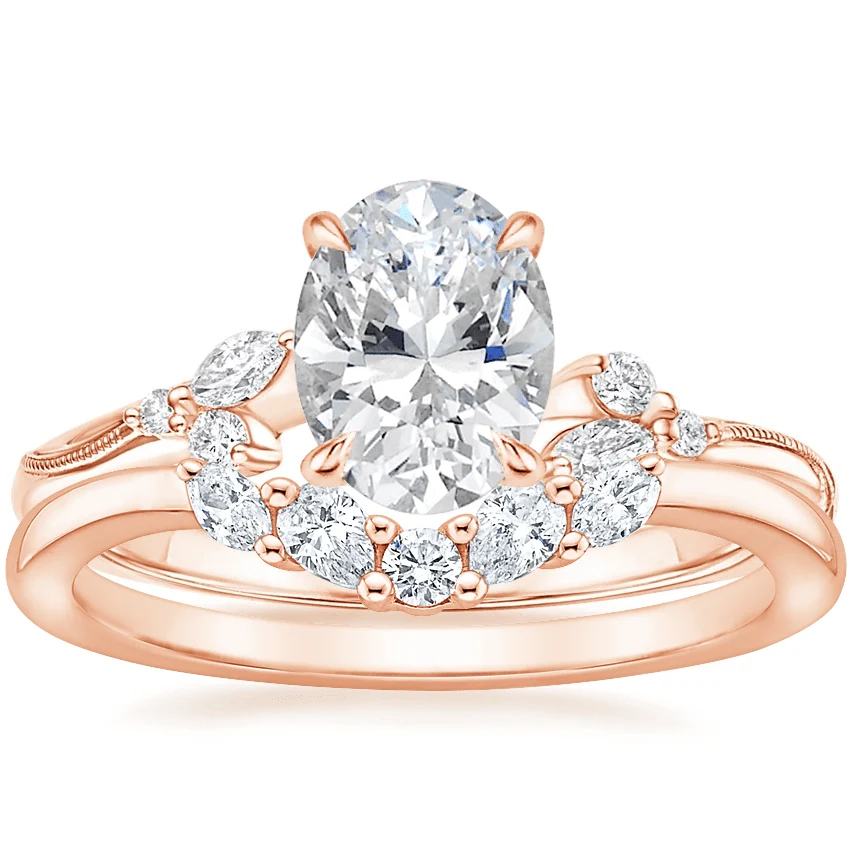 Rose gold oval moissanite engagement ring stacked with matching round and marquise wedding band