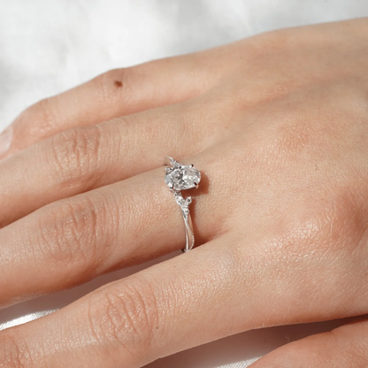 Model hand wearing white gold nature inspired oval moissanite engagement ring