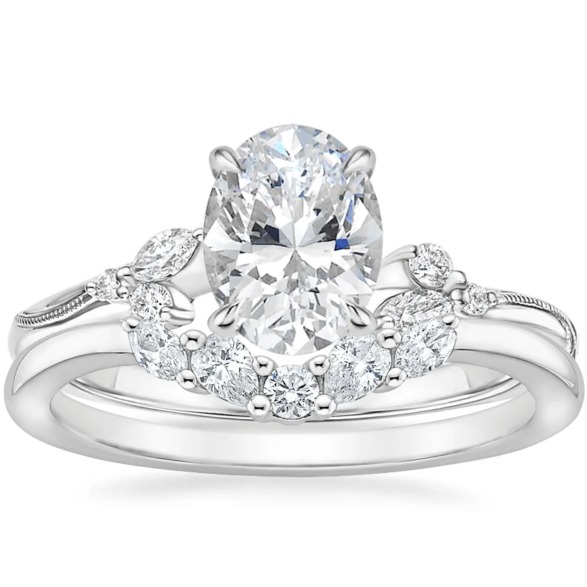 White gold oval moissanite engagement ring stacked with matching round and marquise wedding band