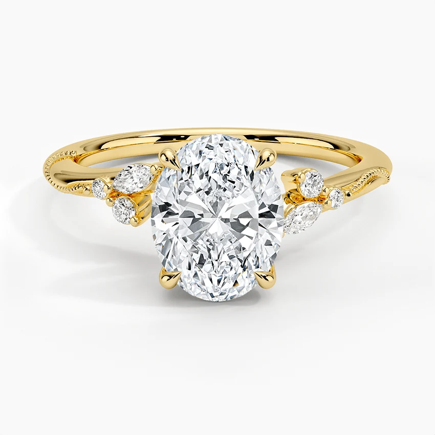 Yellow gold oval moissanite engagement ring stacked with matching round and marquise wedding band