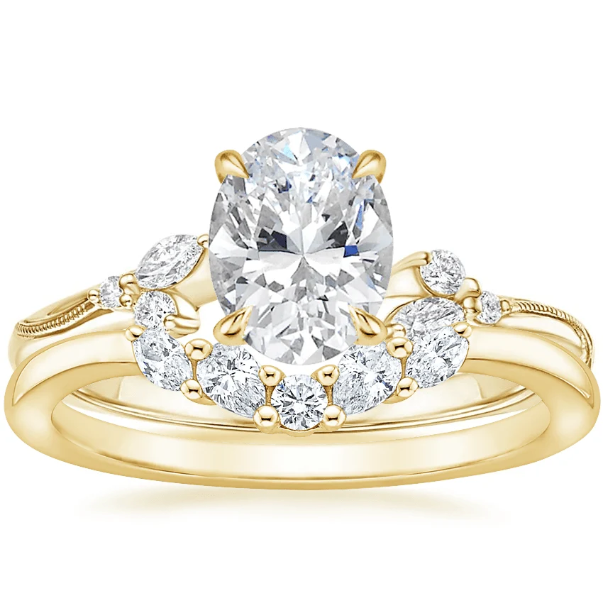 Yellow gold oval moissanite engagement ring stacked with matching round and marquise wedding band