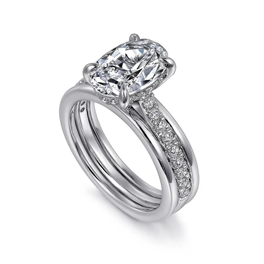 Two-tone white gold oval moissanite engagement ring with hidden halo shown in stacked wedding set view