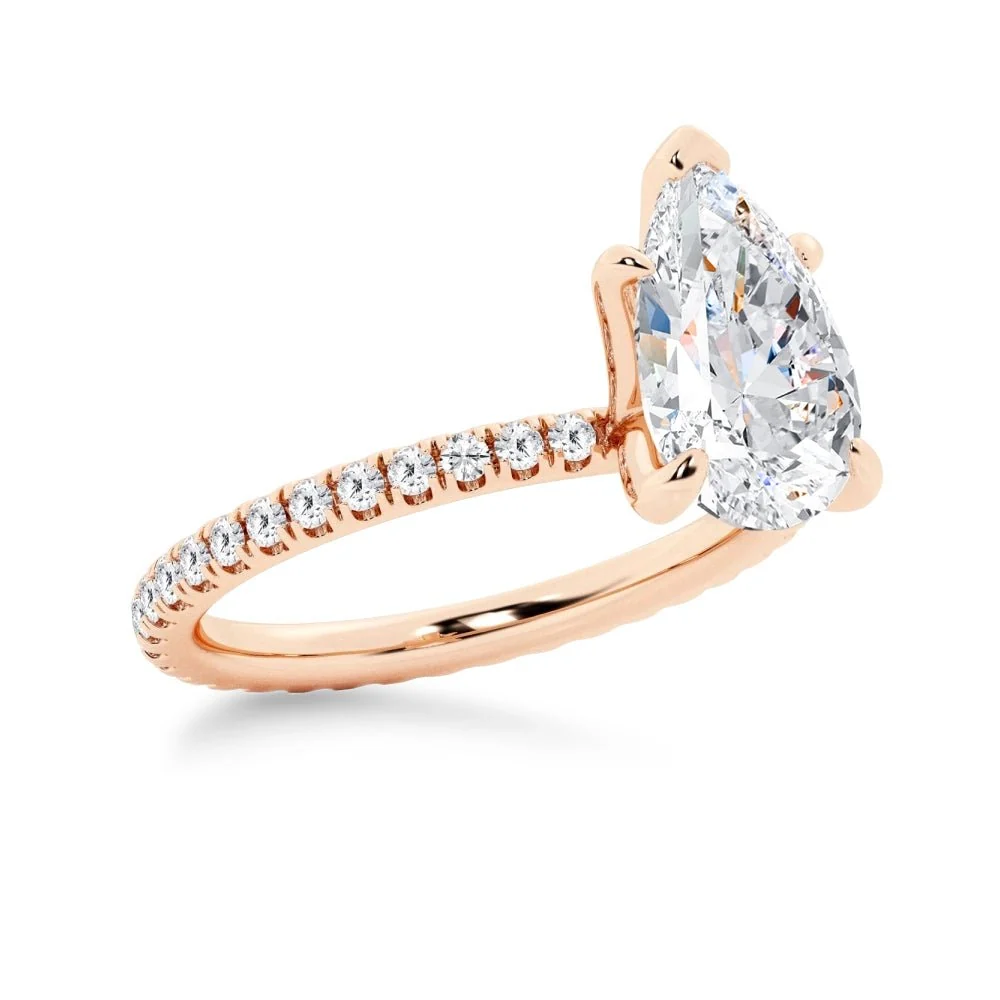 Rose gold pear-cut moissanite engagement ring 3/4 perspective view showcasing pave set band
