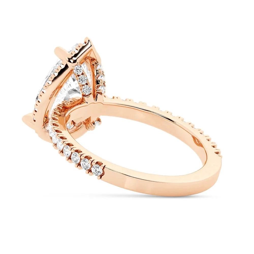 Rose gold pear cut moissanite engagement ring 3/4 angle view showing halo setting and pave band