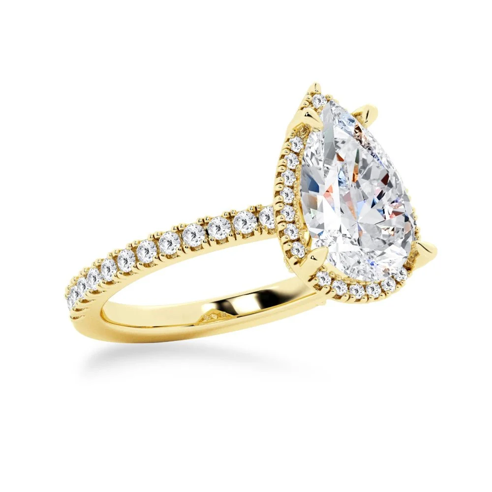 Yellow gold pear cut moissanite engagement ring 3/4 angle view showing halo setting and pave band