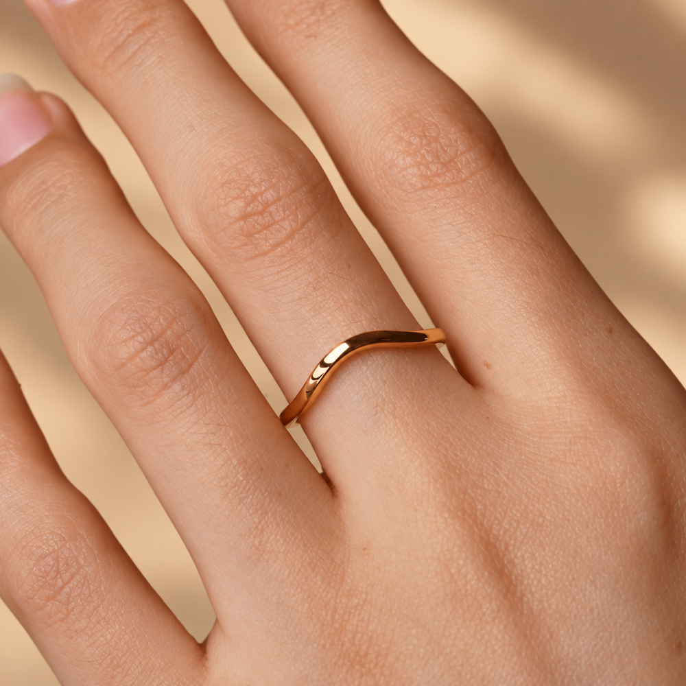 On-finger view of 1.6mm yellow gold high polish plain curved wedding band