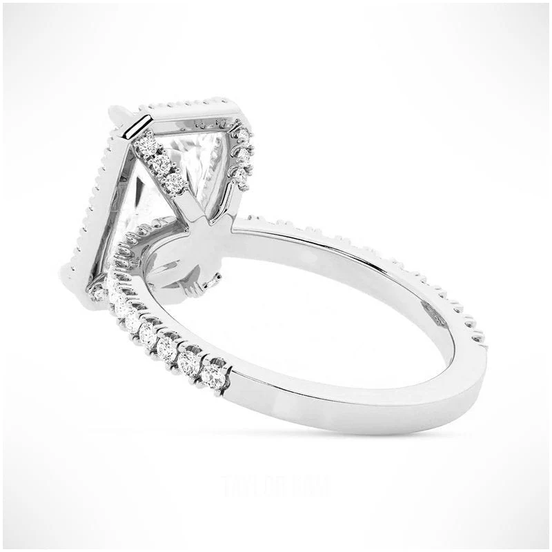 White gold radiant cut moissanite halo engagement ring tilted perspective view with pave band
