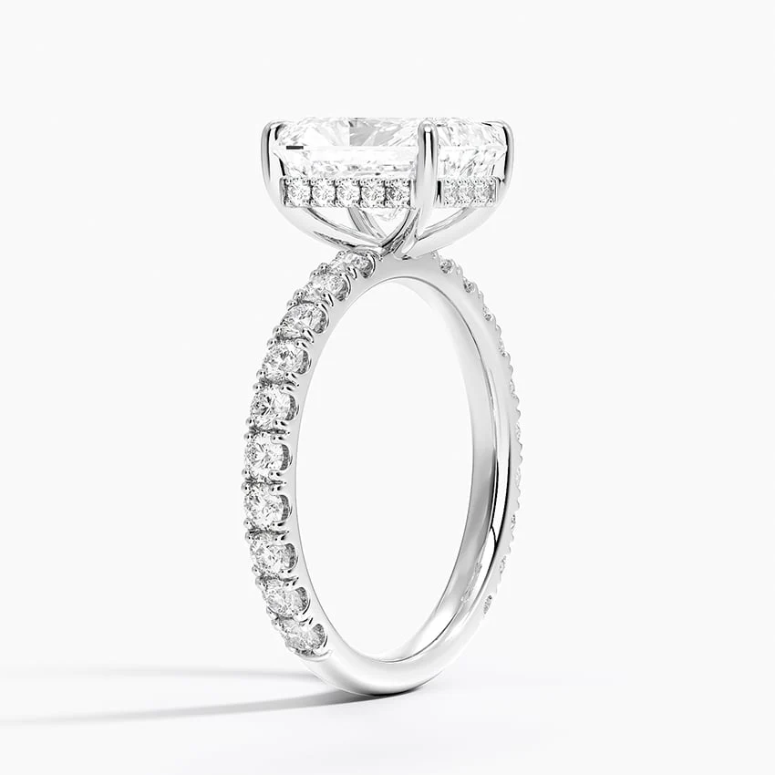 White gold radiant cut moissanite engagement ring 3/4 side perspective view showing claw prongs and scalloped shank