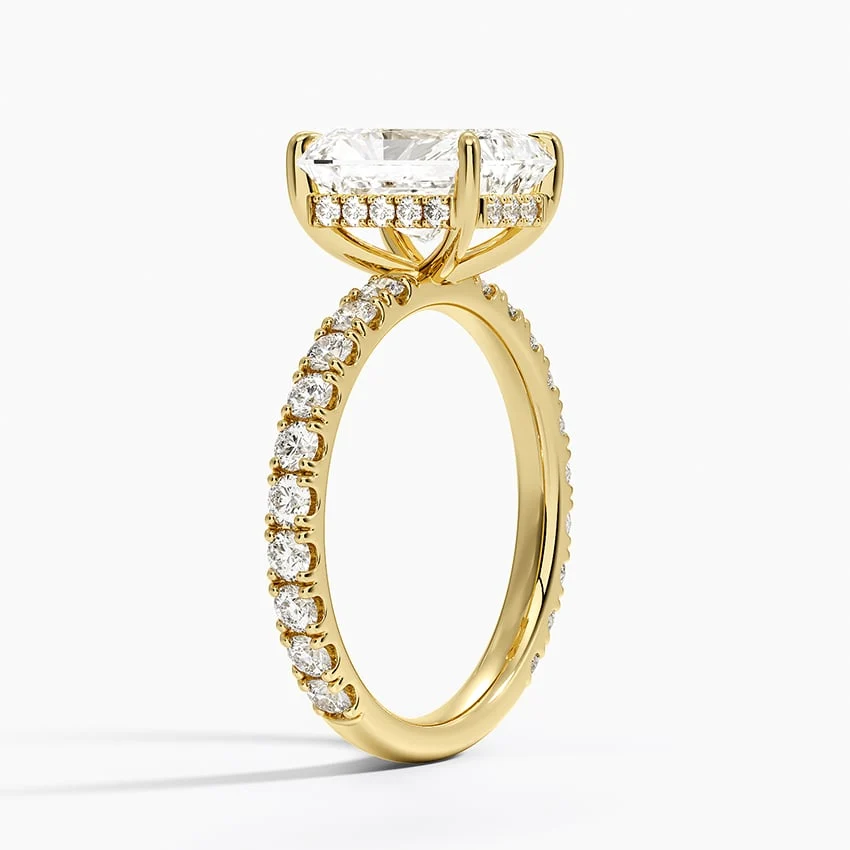 Yellow gold radiant cut moissanite engagement ring 3/4 side perspective view showing claw prongs and scalloped shank